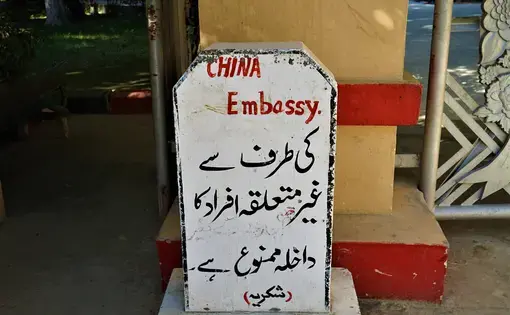 At the site of Chinese government-owned property along the China-Pakistan border, an Urdu-language sign warns that unauthorized visitors will not be allowed entry. Image by Sabrina Toppa. Pakistan, 2018.