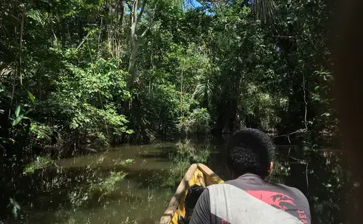 A smuggler guides travelers up the Cacarica River into the heart of the Darien Gap. Photo by Jason Motlagh.  2016.