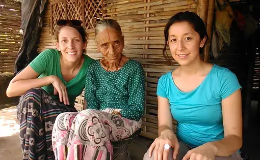 Julia Rendleman (left) and Moriah Balingit (right) visit with Purnawati Timsina at her hut in the refugee camp. Media file: dsc_0568.jpg