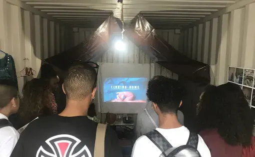 Students watch the trailer for "Finding Home" at Photoville 2017. As part of Photoville's Education Day, Pulitzer Center presented "Finding Home" to students across the four boroughs of New York City. Image by Jordan Roth. United States, 2017.