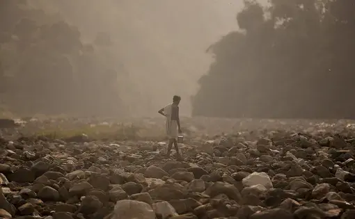 A man finds a spot to bathe along the banks of the Sapta Kosi River in Baha Chhetra. Image by Steve Matzker. Nepal, 2013. Media file: nepal_untold_002.jpg