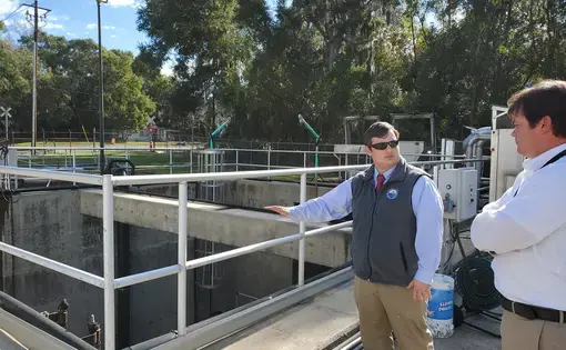 Brunswick-Glynn County Joint Water-Sewer Commission Executive Director Andrew Burroughs and Director of Engineering Todd Klein stand by the wet well at the Academy Creek Wastewater Treatment Plant. Its low walls mean water from a flood could infiltrate it. Image by Emily Jones/GPB News. United States, 2020.
