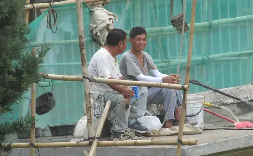 Qiang Zhang (right) and a co-worker talk during lunch break at the Cemiterio de Sao Miguel de Arcanjo. Image by&nbsp;Bruno Beidacki. Macau, 2017.&nbsp;