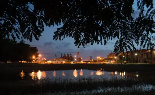 The sky at dusk is cut by the orange glow of the refinery at the Paranam Operations for Suralco, a subsidiary of Alcoa. The plant is no longer operational. Image by Stephanie Strasburg/Pittsburgh Post-Gazette. Suriname, 2017.