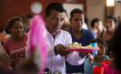 In this July 25, 2019, photo, a Guatemalan man gets a plate of food at El Buen Pastor shelter for migrants in Cuidad Juarez, Mexico. Image by Gregory Bull. Mexico, 2019.
