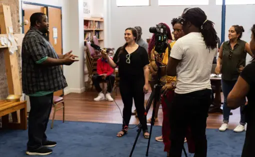 A student interviews a man at Hope House, a transitional home in Chicago, during Free Spirit Media's News West summer program. Image by Claire Seaton. United States, 2019.
