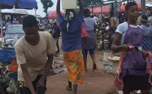 A woman carries a bucket of water on her head at Gosa market. Image by Anita Igbine. Nigeria, 2020.