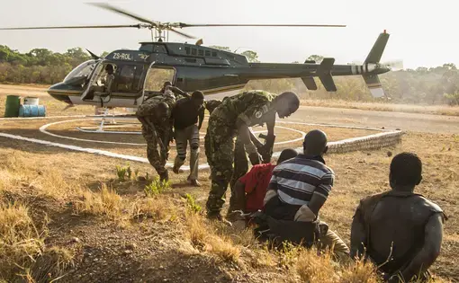 Suspected poachers caught in Chinko arrive at the park’s main base. Rangers put them in handcuffs, sit them down together, then take them to a holding cell. The moment is the culmination of a week-long operation by Chinko’s law-enforcement and aerial patrol teams. Image by Jack Losh. Central African Republic, 2018.