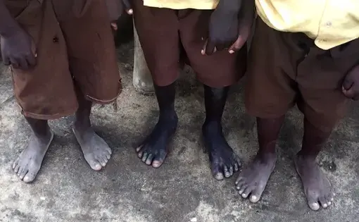 Three boys in the Ponkrom village, dressed in their tattered uniforms, are shoeless. Image by Olivia Conti. Ghana, 2015. Media file: fullsizerender_2.jpg
