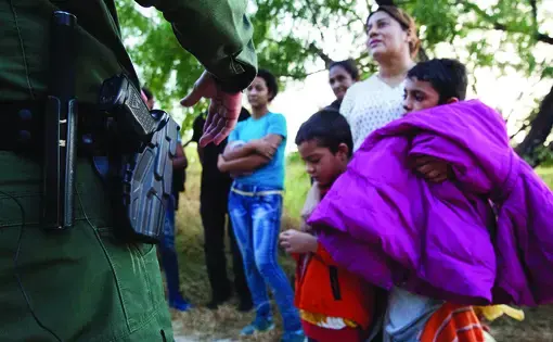 Border Patrol agents apprehend a group of migrants from Honduras at the southern border. Image by Jinitzail Hernández. United States, 2019.