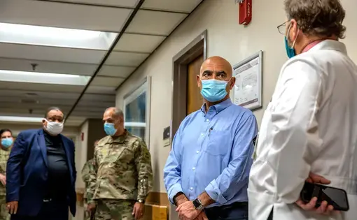 Operation Warp Speed leaders Moncef Slaoui (second from right) and Gen. Gustave Perna (second from left) speak with Cincinnati physicians Carl Fichtenbaum (far right) and O’dell Moreno Owens (far left) during a visit to one of the sites for the efficacy trial of Moderna’s COVID-19 vaccine candidate. Image courtesy of University of Cincinnati Health. United States, 2020.