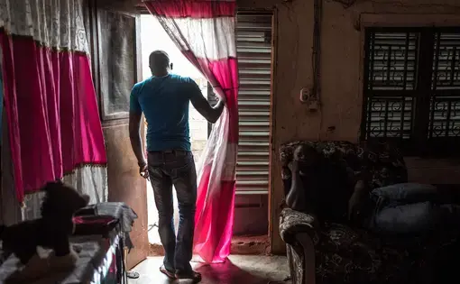 Abdoulaye Traoré stands in the doorway of his uncle’s house in Bamako. Traoré wasn’t sure he could afford to attend law school in the capital, but his uncle agreed to pay the $2.90 in monthly rent for a single room Traoré now shares with two other young men. Image by Nichole Sobecki. Mali, 2017.