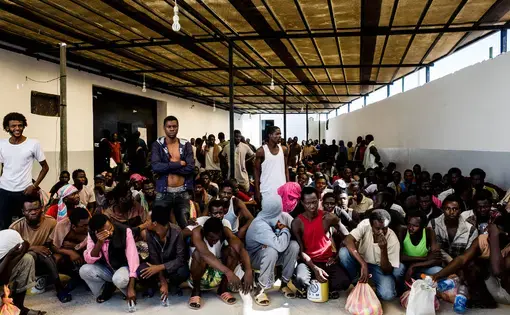 Migrants, mostly from West Africa, wait to receive daily food rations at the Triq al-Sikka detention center in Tripoli, Libya. Image by Peter Tinti. Libya, 2017.