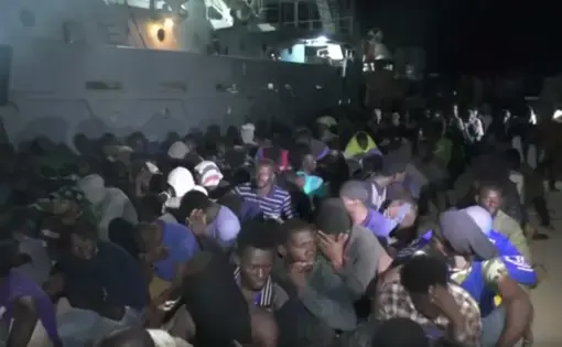 Migrants sit in a shipyard. Port city Sabratha used to be the migrant capital of Libya. Image courtesy of PBS NewsHour. Libya, 2018.