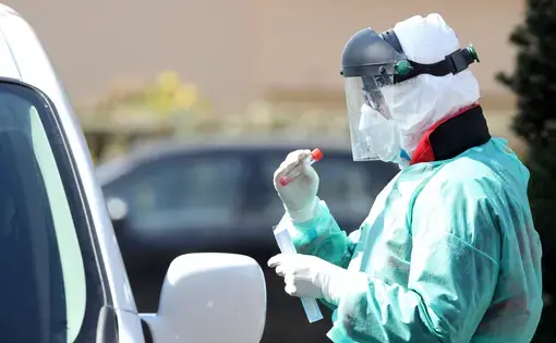 Medical staff member performs&nbsp;coronavirus tests at drive-thru testing point. Image by&nbsp;Damir Sencar / Shutterstock. Croatia, 2020.