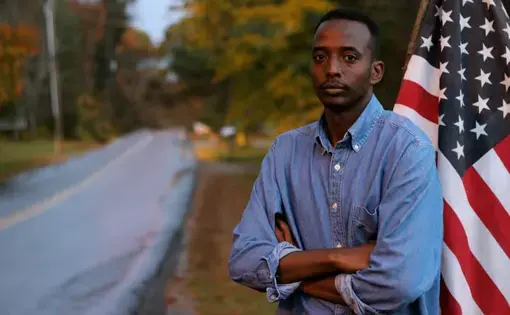 Abdi Nor Iftin in front of the U.S. flag.&nbsp;Image by Leo Hornak.&nbsp;United States, undated.