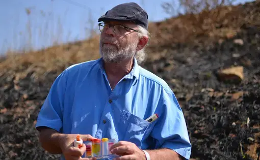 David van Wyk tests water quality in streams near piles of mine waste in Riverlea. Image by Mark Olalde. South Africa, 2016.