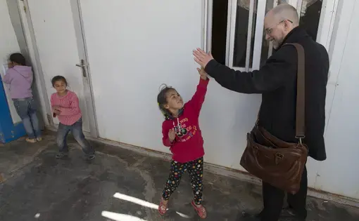 Milwaukee Journal Sentinel reporter Mark Johnson greets Syrian refugee children in the Zaatari refugee camp about 90 minutes north of Amman, Jordan.