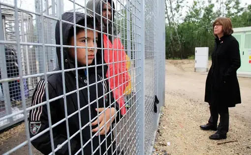 A boy stands at the gate of a refugee camp in Tompa, Hungary. Image by Bence Jardany via Wikimedia Commons. Hungary, 2016.