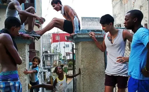 From left, Yosuan Gonzalez, 15, Lazaro Gutierrez, 16, Lorenzo Velasquez, 13, Noel Sandoval, 19, and a friend hanging out in Havana with Emily Chanti, 4, and Yesena Kagemusa, 6. Image by Yana Paskova. Cuba, 2015. Media file: screen_shot_2015-08-13_at_1.36.16_pm.jpg