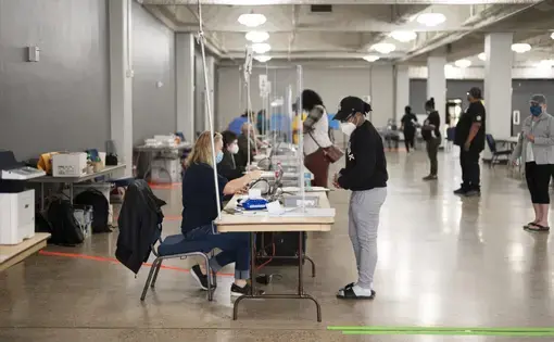 Polls open at the Lake Charles Civic Center on the first day of early voting with short wait times and clear social distancing measures following the “perfect storm, storm, storm” of disasters—a pandemic followed by back-to-back hurricanes. Image by Katie Sikora. United States, 2020.