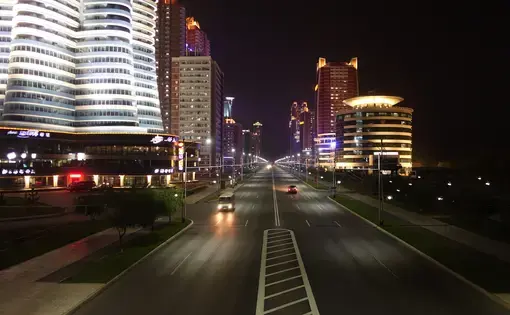 Sparse traffic passes through Future Scientists Street, a gleaming, six-lane avenue that's meant to serve as a showcase for outsiders of Pyongyang's recent development. Image by Laya Maheshwari. North Korea, 2016.