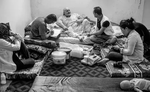 A doctor and technicians record health data on a Syrian refugee in Jordan. Image by Neil Brandvold. Jordan, 2017.