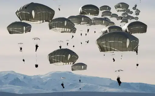 U.S. soldiers drop over the Donnelly Training Area near Fort Greely, Alaska. In October 2018, the training area hosted some 6,000 soldiers during a war games exercise named Arctic Anvil. Image by Louie Palu. United States, 2018.