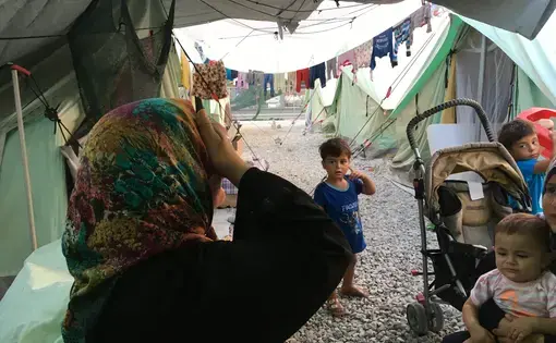A woman and her children at Softex refugee camp in northern Greece. Image by Jeanne Carstensen. Greece, 2016.
