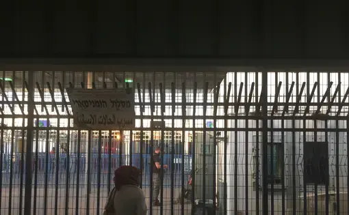 Israeli private security guards chat with Israel Defence Force (IDF) soldiers behind the bars at Qalandia checkpoint. Image by Matt Kennard. West Bank, 2016. Israeli private security guards chat with Israel Defence Force (IDF) soldiers behind the bars at Qalandia checkpoint. Image by Matt Kennard. West Bank, 2016.