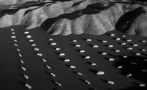 House boats appear next to the shoreline of Bidwell Canyon on Lake Oroville in Northern California on November 25, 2014. Lake Oroville is California's second largest reservoir, and is currently 70% empty as a result of the state's severe drought. Image by Tomas van Houtryve. United States, 2014.