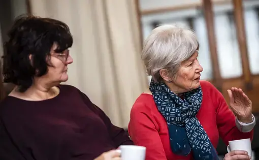 Caroline Mockford, of Govan a neighborhood of Glasglow, left, listens as Sandra Carter, of Edinburgh, speaks during the monthly Poverty Truth Community meeting at The Pyramid at Anderston. Image by Michael Santiago. United Kingdom, 2019.