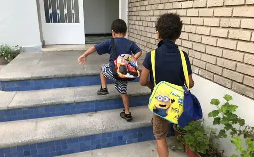 The author's sons, ages 5 and 3, walk up the stairs at their private French school in Morocco. The boys are autistic. Image by Jackie Spinner. Morocco, 2017.