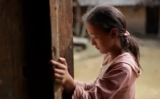 Twelve-year-old Wang Bing stands by the door of her family's farmhouse in Liangshan prefecture, Sichuan province. Image courtesy Max Duncan. China, 2016 