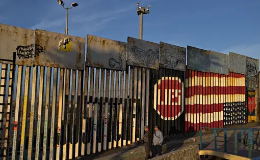 Visitors to Playas de Tijuana stop by the border wall at Friendship Park to look over artwork Dec. 1. Friendship Park is located along the United States-Mexico border in the San Diego-Tijuana region and is a half-acre in size. Image by Amanda Cowan. Mexico, 2019.
