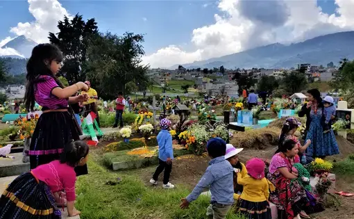Cemeteries throughout Latin America, such as this one in Quetzaltenango, Guatemala, come to life when families decorate the graves of their loved ones with candles, fresh cut grass and flowers. For two days they pray, eat and remember their ancestors in honor of Day of the Dead. Image by Kristian Hernandez. Guatemala, 2018.