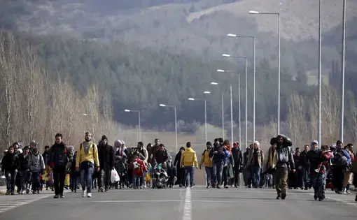 Hundreds of refugees and migrants walk down a road in Greece near the Macedonian border on Feb. 26, 2016. Less than two weeks later, this border closed. Image by Jeanne Carstensen. Greece, 2016.