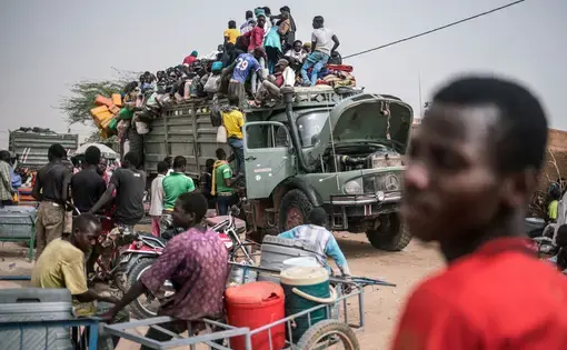 Young men crowd onto the back of an old Mercedes-Benz truck leaving Agadez for the far north of Niger where thousands are prospecting for gold in precarious conditions. Image by Nichole Sobecki. Niger, 2017.