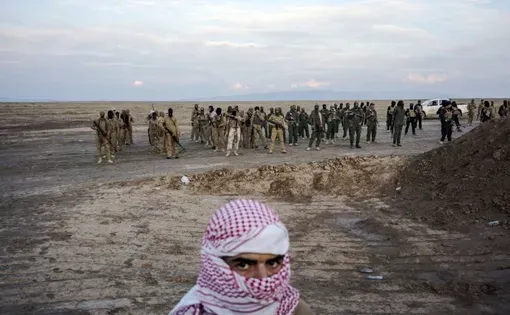 Sunni fighters who oppose the Islamic State take up formation along the front line near the ISIS-controlled village of Haj Ali, south of Mosul. Image by Moises Saman/Magnum Photos. Iraq, 2015.