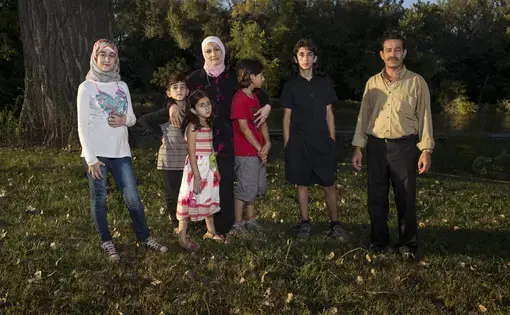 Ghazweh and Abdul Fattah at a park in Des Moines with their children, from left to right: Sedra, Mutaz, Hala, Haidar and Nazeer. Image by Danny Wilcox Frazier—VII for TIME. Des Moines, IA, 2016.