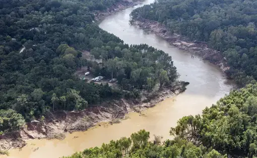 Storm water flowing south from Houston overflowed the banks of the Brazos River, sweeping away trees and earth, and flooding low-lying neighborhoods. Image by Alex MacLean. United States, 2017.