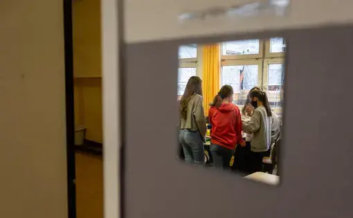 Students working on a book project at the Fritz-Karsen-Shule in Berlin are reflected in a mirror on the classroom wall. Image by Ryan Delaney. Germany, 2020.