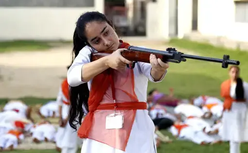 Hindu girls of the Durga Vahini, the 'saffron brigade' women's wing of the Hindu hardliner organization Vishwa Hindu Parishad (VHP), participate in a self-defense training camp, on July 7, 2017 in Jammu, India. Due to the increase in crime against women in the country, the young girls are being given training to operate sticks and guns and to develop the skills of self-defence. Image by Nitin Kanotra / Hindustan Times via Getty Images. India, 2017.