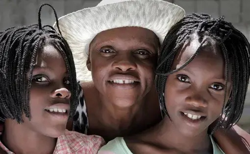 Guerda Janvier (center), who has advanced cervical cancer, wants more than anything to see her 11-year-old twin daughters, Brithney (left) and Briana Osselin (right), grow up.
Image by José A. Iglesias. Haiti, 2018.