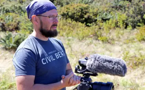 Civil Beat reporter Nathan Eagle preparing for an interview in Hanawai Natural Area Reserve while on assignment covering the endangered kiwikiu in October. Image by Dan Dennison. United States, 2019.
