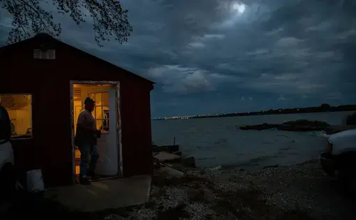 Ernie Thomas arrives early Whites Landing Fisheries in Sandusky, Ohio, to load a catch of catfish on Sept. 26, 2019. He works for commercial fisherman Drew Koch and his father, Dean Koch. Lake Erie, the most populous watershed and productive fishing ground in the Great Lakes, is imperiled each year by toxin-producing bacteria that threatens drinking water and kills fish. The large blooms are fueled by agricultural runoff and increasing heavy rains from climate change. Image by Zbigniew Bzdak. United States…