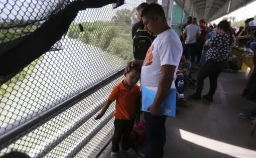 In this Oct. 10, 2019 photo, migrants wait for U.S. authorities to reopen a legal port of entry between Matamoros, Mexico, and Brownsville, Texas, after the bridge was closed briefly by U.S. authorities during a protest by migrants in Matamoros. Mexican gangs have adapted quickly to the new reality of masses of vulnerable migrants parking in the heart of their fiefdom, experts say, treating the travelers, often families with young children, like ATMs, ramping up kidnapping, extortion, and illegal crossings…