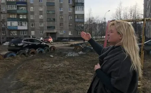 Anna Kireeva near some of the Soviet-era apartment blocks Murmansk, Russia. Image by Amy Martin. Russia, 2018.