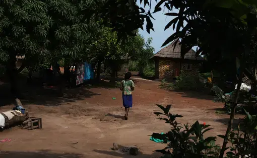 A 17-year-old mother, released by militia forces, walks around the compound where she lives with her two sisters. Like her, and like her grandmother, they were kidnapped and held by rebel soldiers. The girl was pregnant when she was released. Image by Andreea Campeanu. South Sudan, 2018.