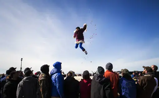 The traditional blanket toss at the annual whaling feast in Point Hope, Alaska on June 16, 2015.
For the Inupiat villagers of Point Hope Nothing is more important than the bowhead whale. The calendar year revolves around hunting, fishing and gathering, a lifestyle Alaskans call “subsistence,” which is as much cultural tradition as economic necessity. The entire village looks forward to spring whaling, and celebrates a successful hunt with an annual feast.
In recent years, however, the much-anticipated whale hunt has run up against a warming Arctic. Ice is getting thinner, windows of opportunity for hunting are shrinking and animal behavior is changing. Alaska had its hottest year on record in 2014, and for Inupiat villagers in Point Hope who have hunted and foraged their meals for generations, climate change now threatens their way of life. The traditional blanket toss at the annual whaling feast in Point Hope, Alaska on June 16, 2015.